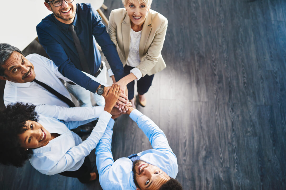 team of people with their hands in a circle